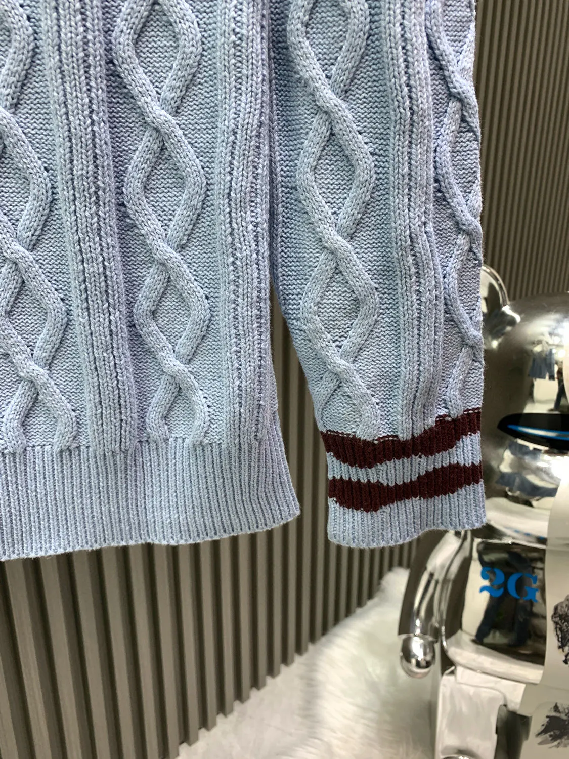 🅿️380 🀄️ Louis Vuitton 25* new autumn and winter cable knitted sheep wool and mohair V-neck pullover This cable knitted V-neck sweater is made of fine mohair and sheep wool, making the scalloped hem of the sleeves complement the wavy intarsia lines on the cuffs and collar. The contrasting 1V intarsia hem on the left adds a college atmosphere to the early spring look. Made of blended wool yarn, 30% wool and 70% acrylic dyed yarn. The process is complex and requires 180 points/piece. This style uses 7-needle Juxin woven pieces. 9 yarn feeders are needed to hang the wool on the front. The whole piece is moved to twist the rope. The intersection of the twisted ropes is prone to holes. The coffee-colored part of the yarn is mohair. The machine adjustment time is long. The needles added at the bottom of the sleeve clips are all edged, which increases the loom time and sewing time. Because the logo is hung with hair, the coffee-colored thread is clamped on the edge and needs to be drawn out. Moreover, due to the characteristics of mohair, hair will fall out when drawing out the thread. It is necessary to manually remove the stray hairs bit by bit, which is very time-consuming. Customized accessories, complete with three standards, same style for men and women.